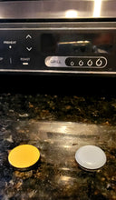 Load image into Gallery viewer, One appliance slider is showing its sticky part (yellow) and the other slider is showing the part that slides (white) on a marble countertop.
