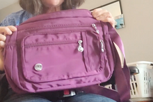 Load image into Gallery viewer, Front view of purple bag with several pockets - three zippers are visible for pockets on the front of the bag.
