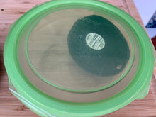 Load image into Gallery viewer, Looking through the see-through green plastic lid at an avocado in the container
