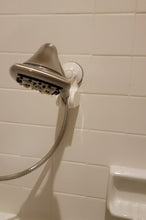Load image into Gallery viewer, Silver shower head in the white shower head holder attached to a white tile while.
