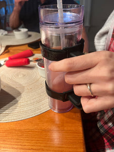 A person is holding the handle that is attached to the cup.