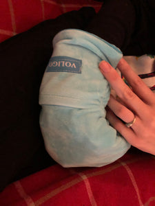 Blue mitt with the tag "Voligo" is being worn. The person's other hand is visible.