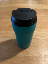 Load image into Gallery viewer, Mighty mug with the flip top lid closed. Teal mug with black lid.
