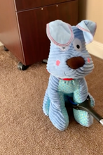 Load image into Gallery viewer, Grabber is closed around the leg of a blue, dog stuffed animal. 
