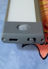 Load image into Gallery viewer, The end of the light strip unit, showing a small on-off switch and a charging port.
