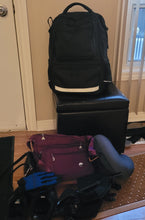 Load image into Gallery viewer, The purple bag is sitting in the middle of a pile of things ready for a trip.
