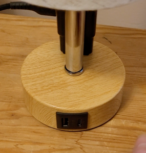 A view of one USB and one USBc port on the wooden base of lamp.
