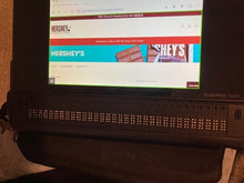 Load image into Gallery viewer, The tablet screen shows the Hershey&#39;s website. Beneath the screen is are 32 braille cells that go across the length of the device.
