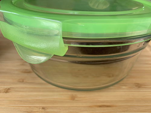 Close up of green plastic lid clasped onto the glass container