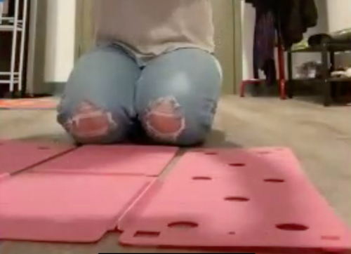 Pink FlipFold device is laid out on the floor. It has various sections, and a person is kneeling on the floor behind it.