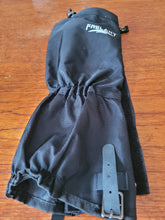 Load image into Gallery viewer, Black gaiter laying on a table. It gathers at the ankle, has a buckle strap at the bottom, a drawstring tie at the top, and the white brand name &quot;Frelaxy&quot; printed on the side.
