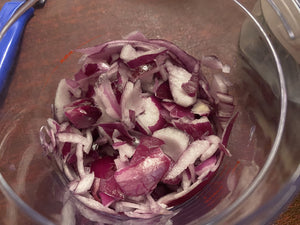 Looking into the clear container to see roughly chopped onions. 
