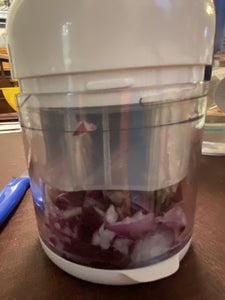 Side view of chopped onions through thee clear, base container.