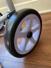 Load image into Gallery viewer, Close-up of wheel, black with white spokes and a black middle point with a silver clasp.
