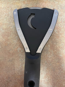 OXO Good Grips Jar Opener, which has metal teeth set in a "V" shape so that it can open most jar or bottle sizes. The device, which is black, has a wide, ergonomic handle and a cutout arrow pointing in the direction you should turn the handle.