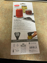 Load image into Gallery viewer, The back of the OXO Good Grips packaging, which says &quot;Jar Opener with Base Pad&quot; and highlights its various features and shows it in use. 
