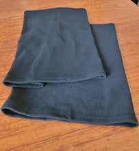 Load image into Gallery viewer, Two black fleece neck warmers are laid out on a wooden table.
