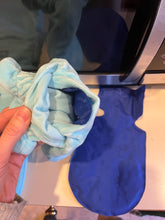 Load image into Gallery viewer, Opening for inserting gelpack with blue gel pack inside and one sitting beside the mitt on a counter.
