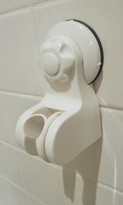 White shower head holder, showing its attachment to the wall and the slot for the shower head handle. The white button is in the middle and the knob around the button is then used to further tighten it.
