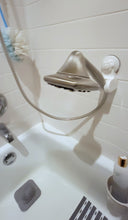 Load image into Gallery viewer, View of the silver shower head attached to a lower spot on the wall, hanging over the middle of the bathtub. 
