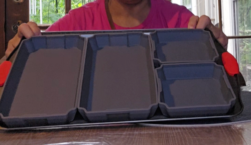 Close up of the four gray silicone baking pans on a cookie sheet. Two are larger and then the last two are small square pans.