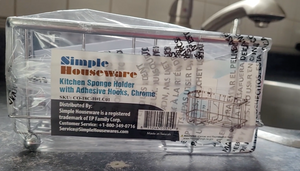 Silver sponge holder in plastic packaging that says "simple houseware Kitchen Sponge Holder with Adhesive Hooks, Chrome"