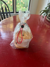 Load image into Gallery viewer, The red tie has been drawn shut with the black slider around the top of a plastic bag with bagels inside.
