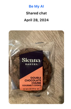 Load image into Gallery viewer, Text: Be My AI, Shared Chat, April 28, 2024. A large double chocolate chunk gourmet cookie from Sienna Bakery is wrapped in clear plastic and sitting on a table.
