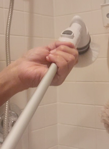 A hand holding the Turbo Scrub cleaning tool close to the brush head.