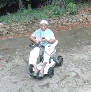 Karen putting the ZoomBroom cordless tick blower across her lap in her power chair.