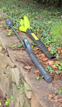 Load image into Gallery viewer, Full length shot of ZoomBroom laying beside a cordless, traditional leaf blower that has is bulkier at the handle.
