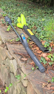 Full length shot of ZoomBroom laying beside a cordless, traditional leaf blower that has is bulkier at the handle.