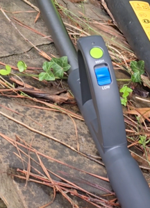 Close up of the green push power button and the large blue "high/low" switch on the handle.