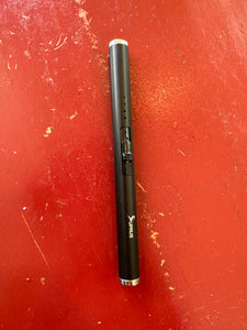 Black lighter that looks like a pen, with a black switch in the middle to be pushed up or pulled back. The Suprus logo is one one end.