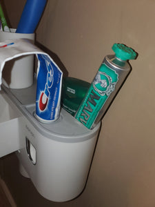Another angle of the top of the toothpaste dispenser, where the toothpaste tube is inserted upside down into the dispenser.