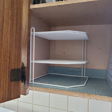 Load image into Gallery viewer, Corner rack sitting in shelf without any plates. The rack is white and creates two additional shelves in the cabinet.

