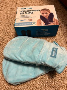 Blue mitts with the word "voligo" are sitting on the floor beside the box that they were delivered in. 