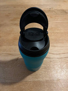 Top view of mug with the lid flipped up/open, revealing the hole to drink out of. 