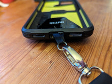 Load image into Gallery viewer, Silver clasp of lanyard connected to a small silver ring that is attached to the phone with a black fabric loop.
