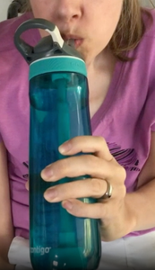 Photo of a person drinking from the water bottle.