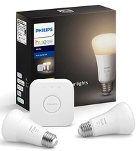 Load image into Gallery viewer, Black box with a light bulb on it and the words Philips and Hue. In front of the box are two lightbulbs and a small white square &quot;hub&quot; that says Philips on the front.
