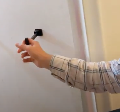 A person is grabbing the t-pull to close the door. 