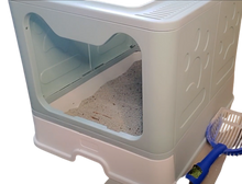 Load image into Gallery viewer, Post-cleaning view of the cat litter box. Light sea-foam green container with cat-shaped opening, white litter drawer/tray, and blue shovel tool beside the litter box. 

