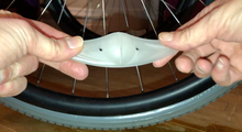 Load image into Gallery viewer, Front of spoke light (not lit up) showing the slit and two small holes on either side.
