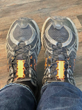 Load image into Gallery viewer, Top-down photo of black athletic sneakers with orange Zubits magnetic shoelaces holding the laces in place.
