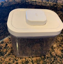 Load image into Gallery viewer, Pop container, clear with a white lid, sitting on a marble countertop. The &quot;pop&quot; button on the lid is released.
